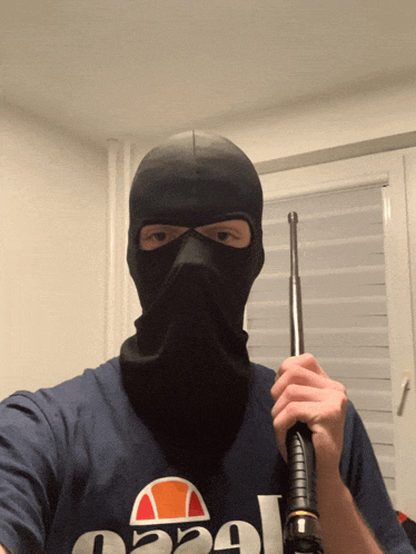 a man wearing a mask and a shirt that says ellesse