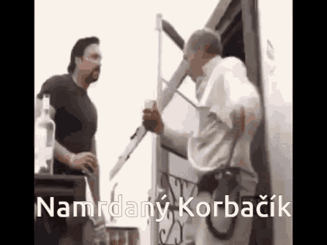 a man is holding a knife and talking to another man in front of a truck .