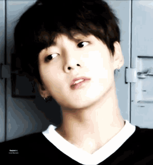 a close up of a young man 's face with the name taehyung on the bottom right