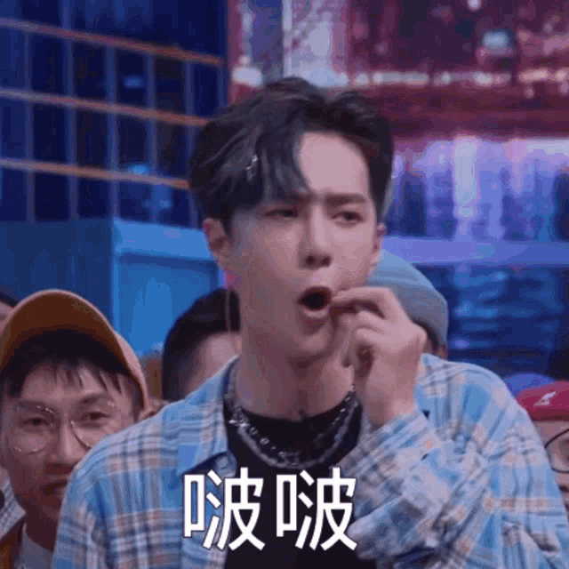 a man in a plaid shirt is eating a piece of food .