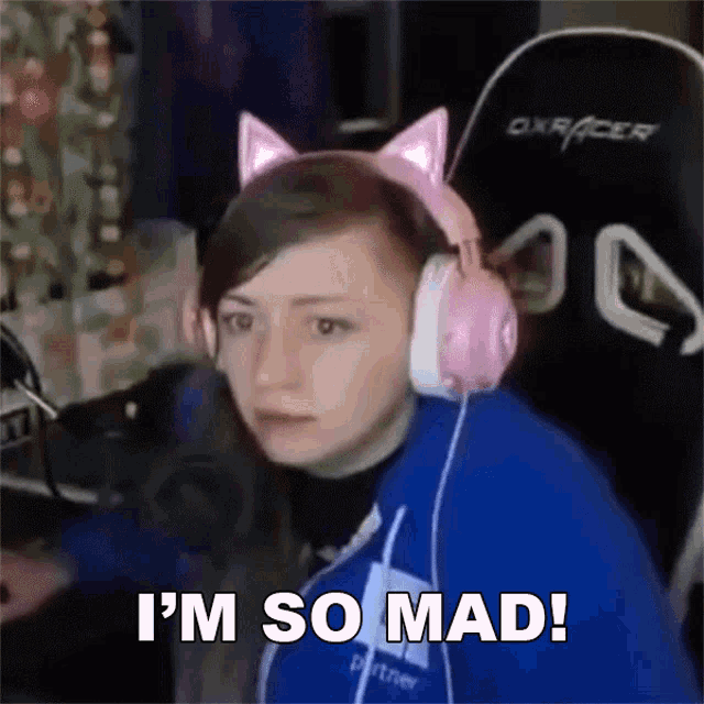 a woman wearing pink headphones and a cat ear headband says i 'm so mad