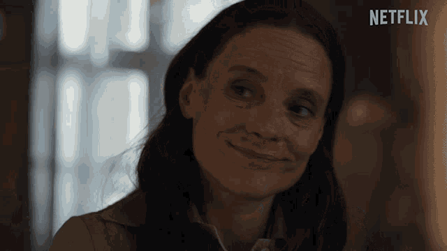 a woman is smiling in front of a screen that says netflix