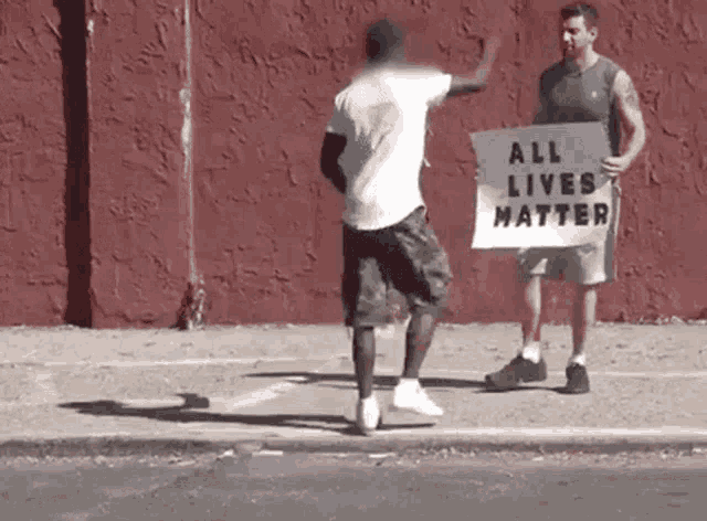 a man holding a sign that says " all lives matter "