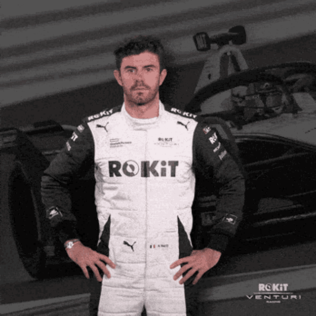 a man standing in front of a rokit venture race car