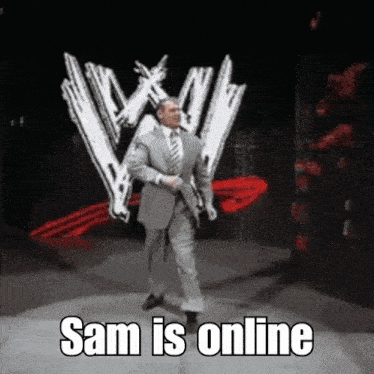 a man in a suit and tie is standing in front of a wrestling logo and says " sam is online "