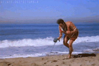 a man is using a metal detector to search for something on the beach .