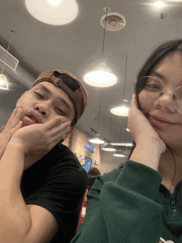 a man and a woman are posing for a picture and the woman is wearing glasses
