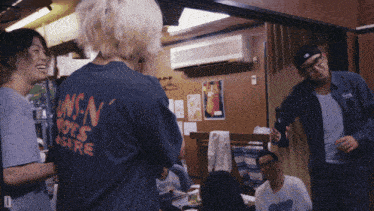 a man wearing a shirt that says guns n ' roses is standing in a room
