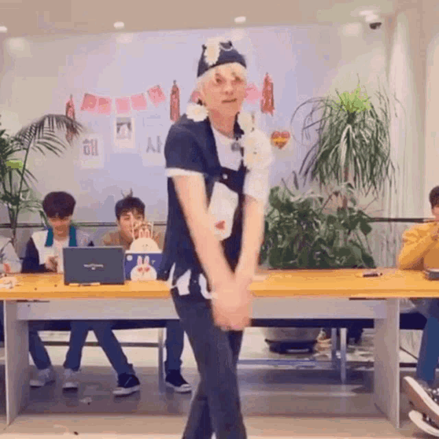 a man is dancing in front of a group of people sitting at a table .