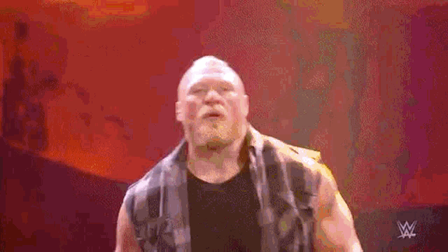 a bearded wrestler is making a heart shape with his hands .