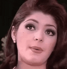a close up of a woman 's face with a pearl necklace .