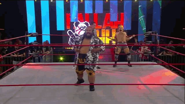 a wrestler in a hawaiian shirt is standing in a wrestling ring