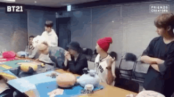 a group of people are sitting around a table with balloons on it .