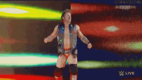 a wrestler is dancing in front of a screen that says sky sports live