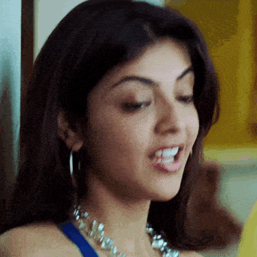 a close up of a woman wearing a necklace and hoop earrings