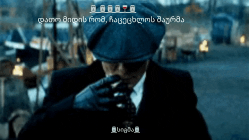 a man in a suit and hat is smoking a cigarette in a dark room