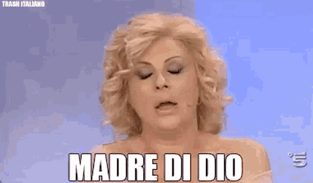 a woman is crying and covering her face with her hand while saying madre di dio .