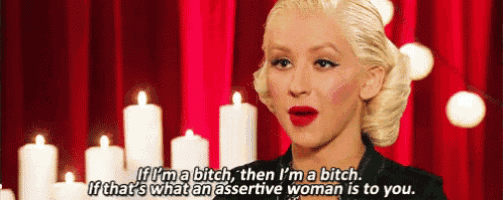 a woman is standing in front of a red curtain with candles and says if i 'm a bitch