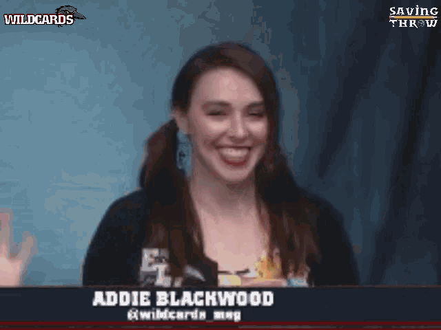 a woman named addie blackwood is smiling in front of a sign that says wildcards