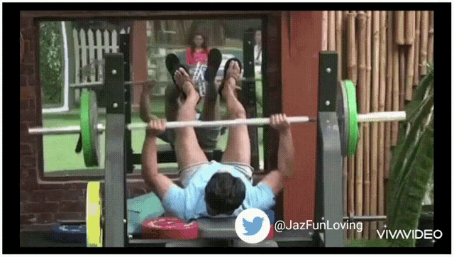 a man is lifting a barbell on a bench with a twitter logo