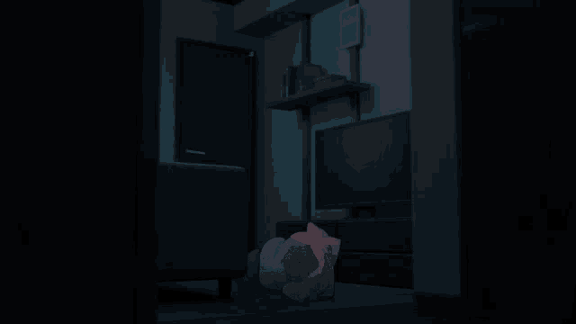 a dark room with a couch and a tv