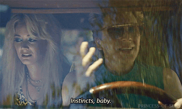 a man is driving a car with a woman in the back seat saying instincts , baby .