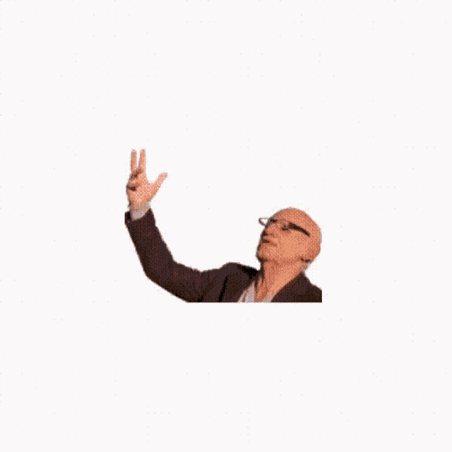 a bald man in a suit and glasses is reaching up towards the sky .