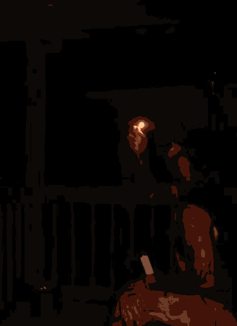 a man is sitting on a balcony with a cell phone and a flame coming out of his hand