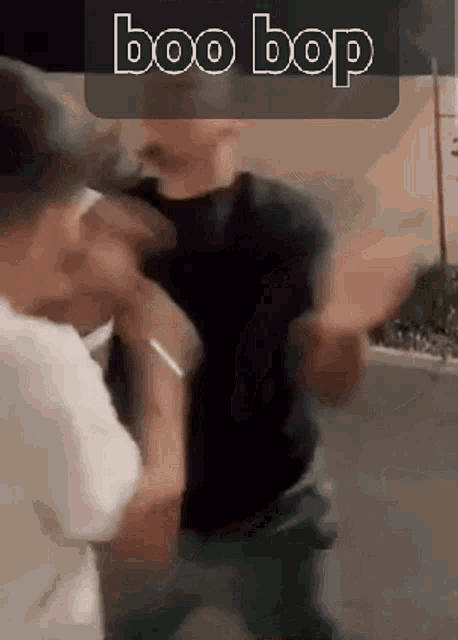 a man in a black shirt is fighting another man in a white shirt .
