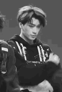 a black and white photo of a young man wearing a hoodie that says mind of