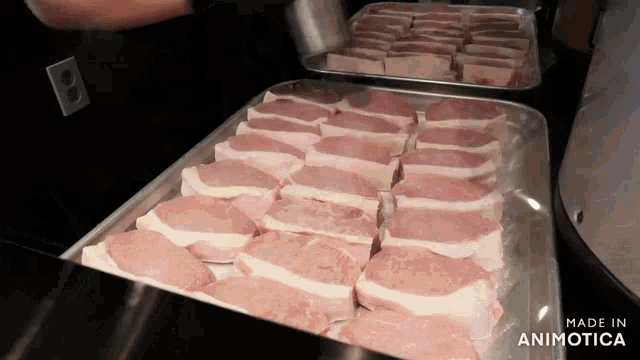 a tray of raw pork chops with the words made in animotica below it