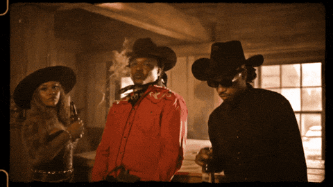 a man in a cowboy hat is smoking a cigarette next to a woman