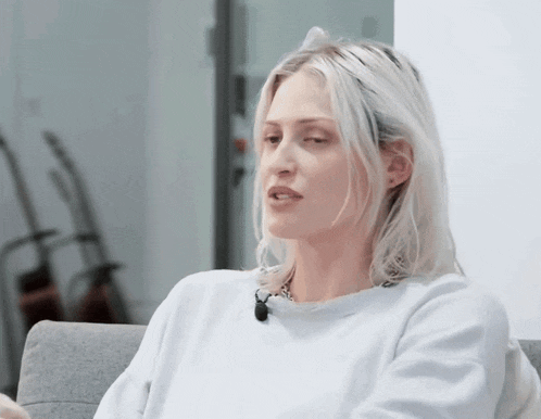 a woman with blonde hair is wearing a white shirt