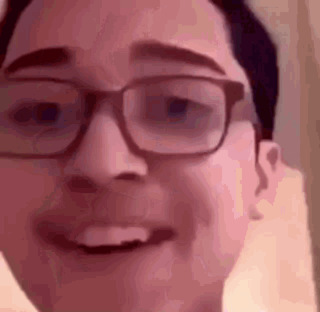 a close up of a person 's face with glasses on .