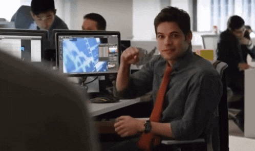 a man sitting in front of a computer with a screen that says microsoft