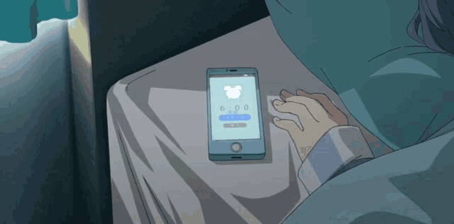 a person laying in bed looking at a cell phone that says 6:00 on the screen