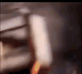 a close up of a person 's hand holding a lighter in a dark room .