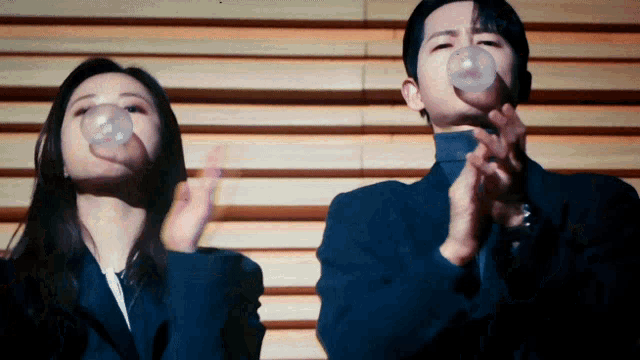 a man and a woman blowing bubbles with their hands