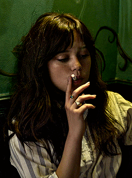 a woman with a ring on her finger is smoking