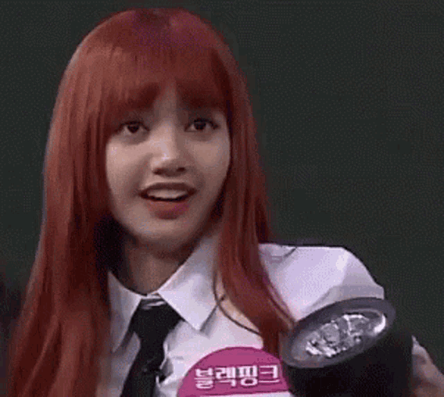 a woman with red hair and a tie is holding a flashlight .