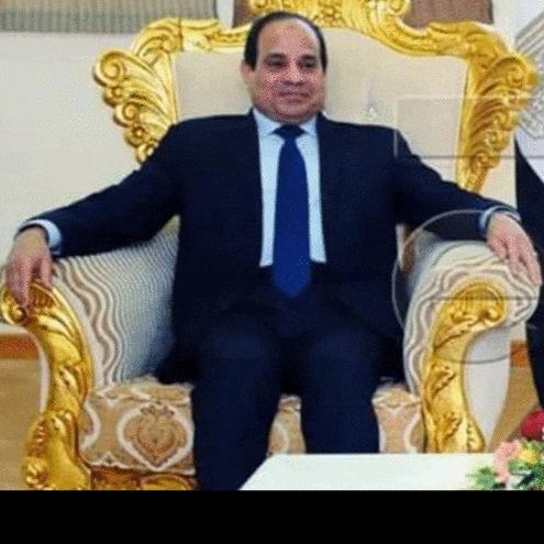 a man in a suit and tie is sitting on a chair