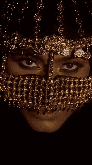 a close up of a woman 's face with a gold veil