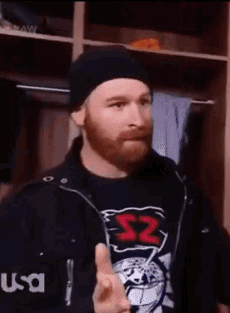 a man with a beard is wearing a black shirt with the number 52 on it .