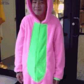 a person wearing a pink and green costume is standing in front of a door
