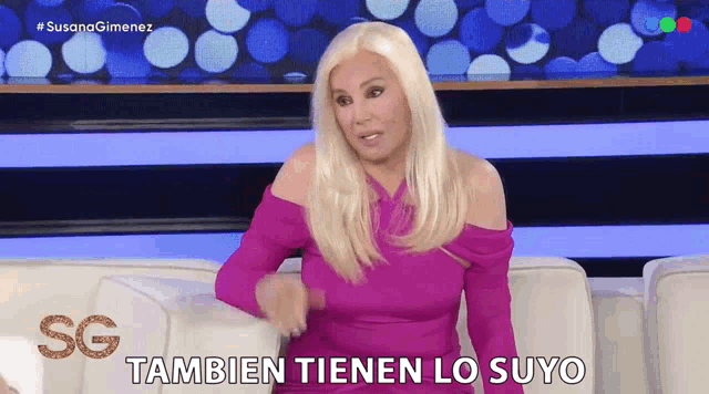 a woman in a purple dress is sitting on a couch and says tambien tienen lo suyo