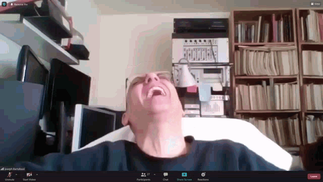 a man is laughing in a video call with joseph baraffond