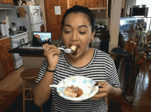 a woman is eating a piece of cake with a fork