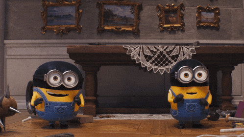 two minions are standing in front of a table with a sign that says awww on it