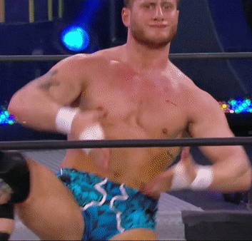 a wrestler without a shirt is standing in a wrestling ring
