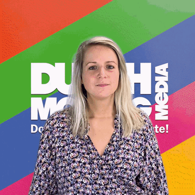a woman in a floral shirt stands in front of a colorful background that says " duh media "